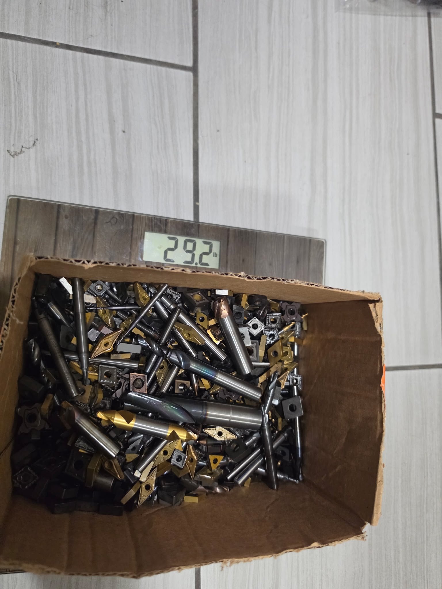 Box of carbide scrap on a scale showing weight before quote review.
