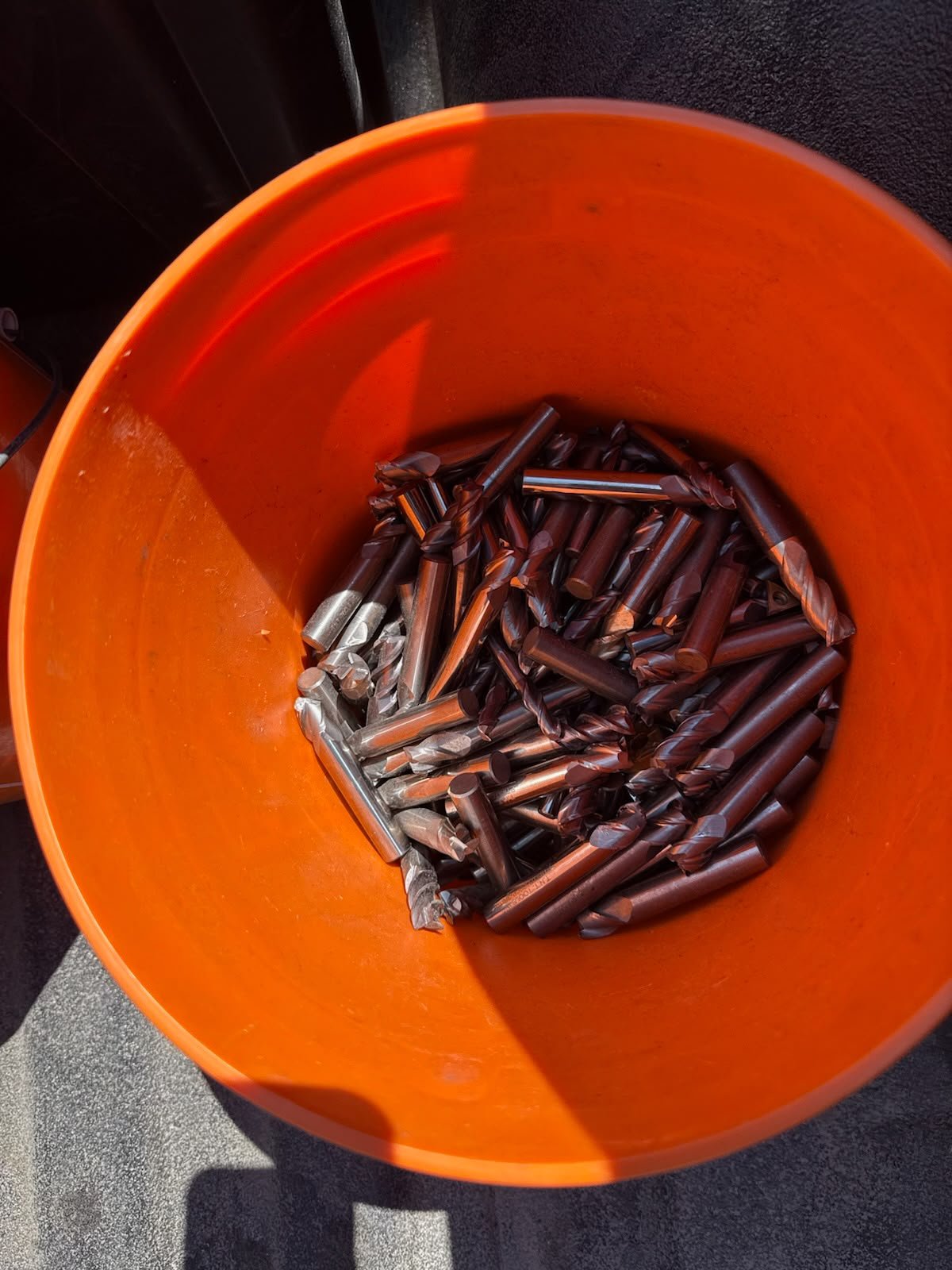Solid carbide tools and drills grouped in an orange bucket.